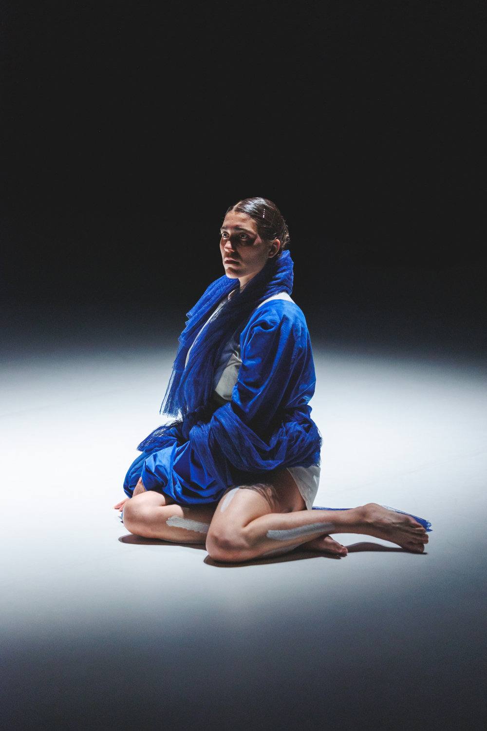 La danseuse Lea Anderson a genou dans un bain de lumière, création lumière de Jérôme Baudouin, créateur lumière en danse, théâtre et spectacle vivant